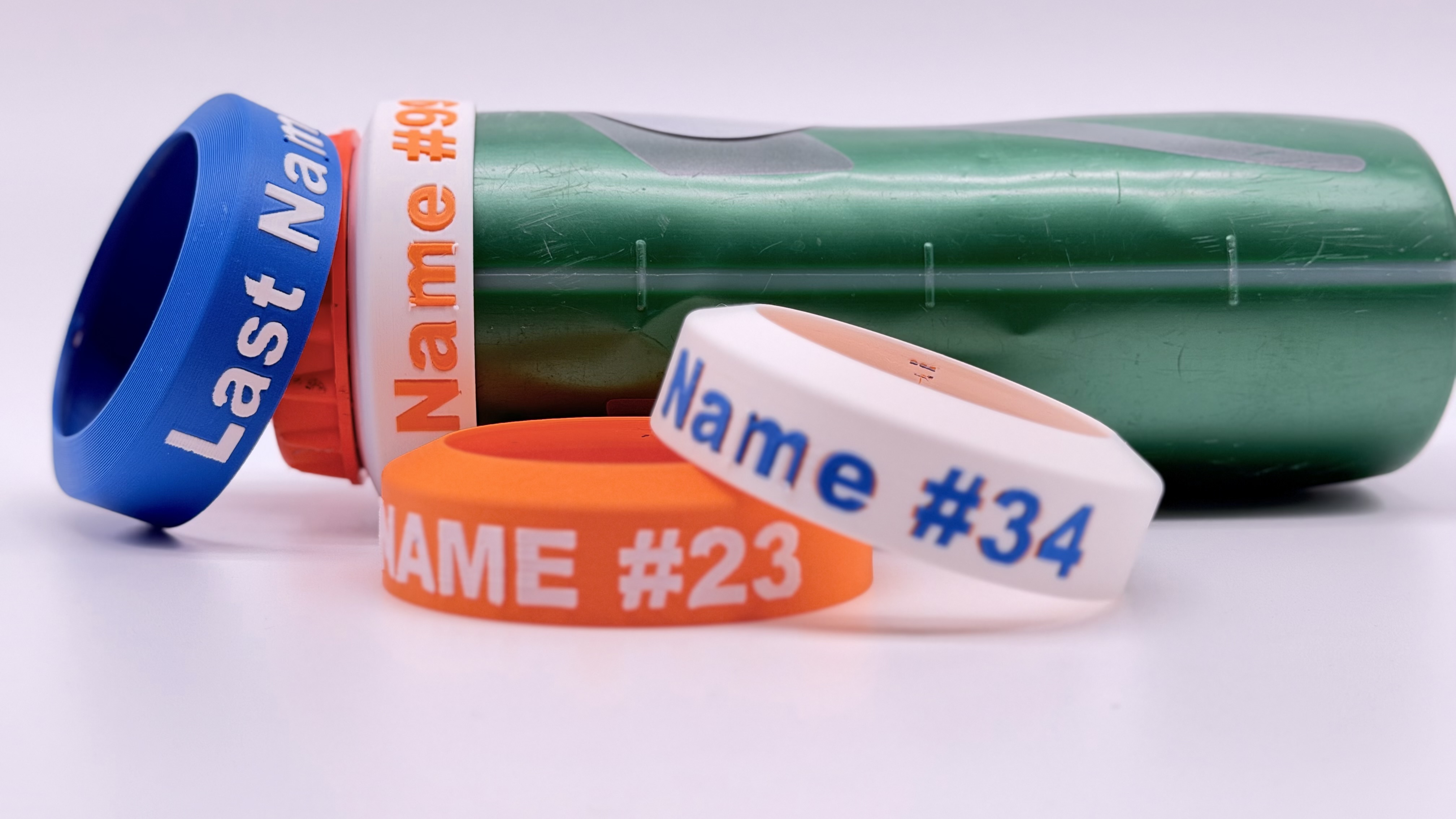 Four name rings in blue, orange and white, reading Last Name, Name #9, Name #23 and Name #34